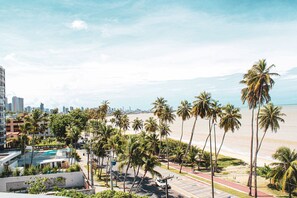 A coastal cityscape with palm trees, a beach, and high-rise buildings. - Setai Yacht Premium II - By Almare Flats (João Pessoa)