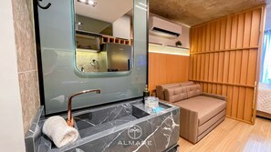 A bathroom with a marble sink, a towel, a mirror, and a wooden panel wall.