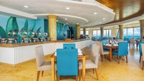 Ein geräumiges Restaurant mit hoher Decke, großen Fenstern und einer zentralen Bar.