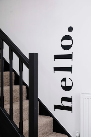 Staircase leads to an upper floor with a welcoming message.