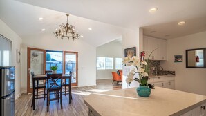 Una cocina amplia con una isla grande, piso de madera y muebles de cocina modernos.