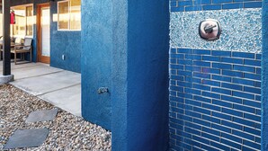 Fachada de edificio con pared azul, sección de azulejos y una puerta.