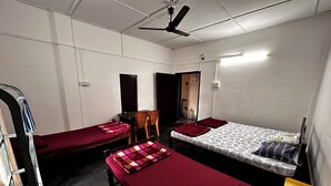 Une chambre de dortoir avec deux lits simples, un bureau et une chaise.