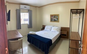 A bedroom with a bed, a desk, a chair, a wardrobe, and a window with curtains. - Hotel Estrela (Castanhal)