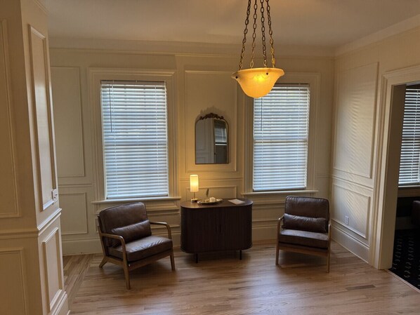 A room with two leather chairs, a round table, and a hanging light fixture. - Remodeled Downtown Historic Home, close to beach, McMorran, Marina (Port Huron)
