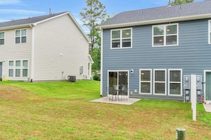 A residential building with a covered patio area and a small outdoor seating space. - The Spartan Retreat | Luxe 3BR | Sleeps 10 (Spartanburg)