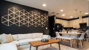Un salon moderne comprenant un canapé, une table basse et un coin repas avec des chaises et une table.