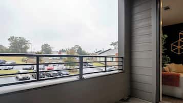Ein Balkon mit Blick auf einen Parkplatz und eine Straße.