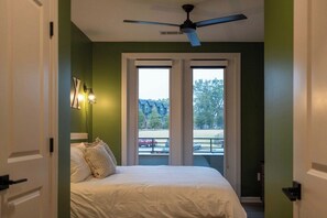 A bedroom with a bed, a ceiling fan, and a view through a door to an outdoor area. - Luxe Modern Loft, Great for Long Stays W/King Beds (Spartanburg)