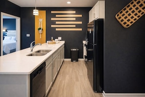 A modern kitchen with a dishwasher, sink, and black refrigerator. - Amazing location, 2 King beds, Modern loft (Spartanburg)