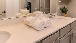 A bathroom with a sink, mirror, and towels. - Ideal for long stays, great location, King bed! (Spartanburg)