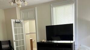 Ein Wohnzimmer mit Fernseher, Sofa und Couchtisch.