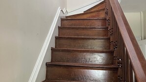 Eine Holztreppe mit weißen Wänden und einem Holengeländer.