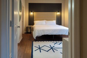 A bedroom with a bed, bedside tables, and a patterned rug. - 3 King Beds, Perfect for Long Stays (Spartanburg)