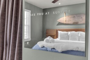 Ein Schlafzimmer mit einem Bett, einem Kopfteil und einer Wand mit Schrift.