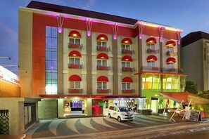 Hotel features a modern architectural design with a flat roof and balconies with awnings.