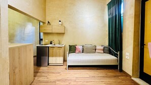 A compact room with a kitchenette, a bed, and a window with curtains. - SA Studio 24 (Tirana)