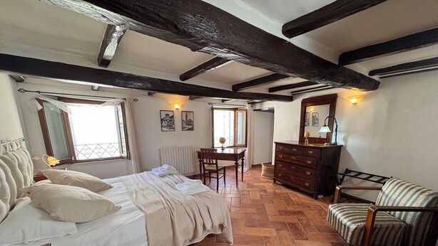 A bedroom with a bed, a dresser, a chair, and a desk.