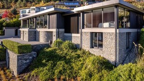 A modern two-story house with large glass windows and a stone facade. - The Belfast (Queenstown)