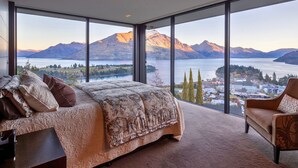 A bedroom with a large bed and a view of mountains and a lake. - The Belfast (Queenstown)