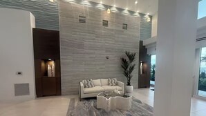 Un vaste espace de vie agrémenté d’un canapé moderne, d’une table basse originale et d’une grande fenêtre offrant une vue sur l’extérieur.