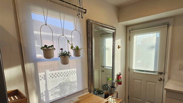 A bathroom with a wooden vanity, a mirror, and three hanging potted plants. - Quiet & Quaint 2 Bedroom 1 Bath with Yard (Fort Lee)