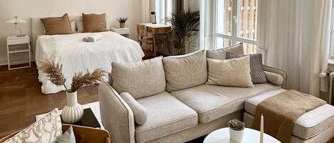 A spacious living room with a large sofa, a coffee table, and a dining area.