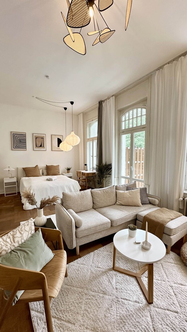A spacious living room with a large sofa, a coffee table, and a dining area.