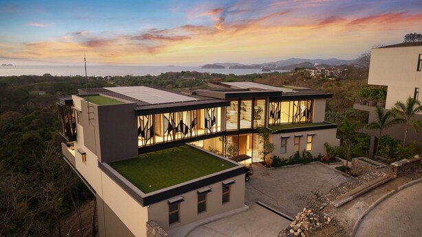 A modern house with a flat roof, large windows, and a well-maintained lawn. - Villa Zaya - Designer Ocean-View Villa in Reserva Conchal (Santa Cruz)