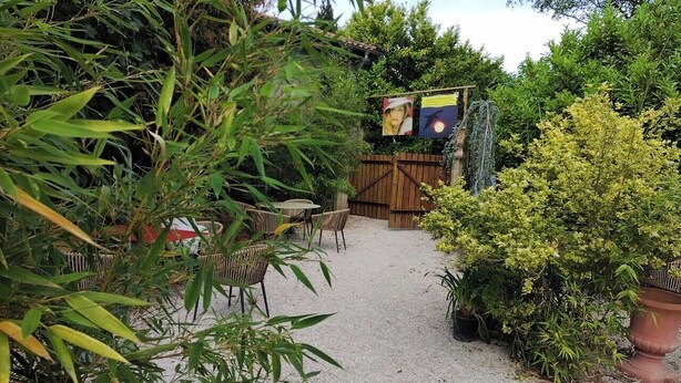 A garden area with a gravel path, wicker furniture, and potted plants. - Hostelry private (Écully)