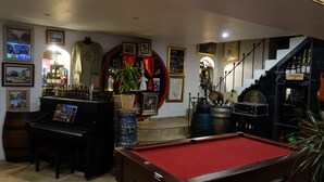 A bar area with a pool table, a piano, and various bottles and framed pictures on the walls. - Hostelry private (Écully)