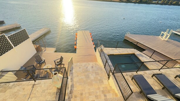 A sunlit deck with a pool, lounge chairs, and a staircase leading to the water. - Luxury Riverfront Home in Parker - Private Dock, Mini Pool & Game Room (Parker)