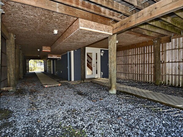 Un couloir intérieur avec des poutres en bois, une porte et une clôture en bois.