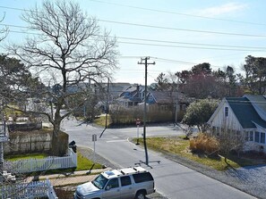 Une rue résidentielle bordée de maisons, avec un panneau de signalisation et un ciel dégagé.
