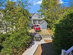 A residential property with a driveway, a red vehicle, and a garage.