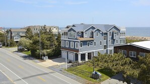 Un immeuble résidentiel à deux étages, doté d’un garage, d’une allée et offrant une vue sur l’océan.