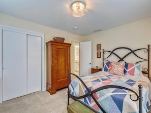 A bedroom with a bed, a wardrobe, and a nightstand. - Oceanview Beach House w/ Outdoor Lounges (Bethany Beach)