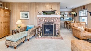 Una sala acogedora con chimenea, paneles de madera y asientos cómodos.