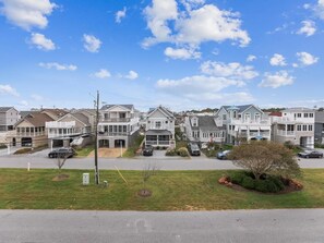 A residential area with houses, a clear sky, and a well-maintained lawn.