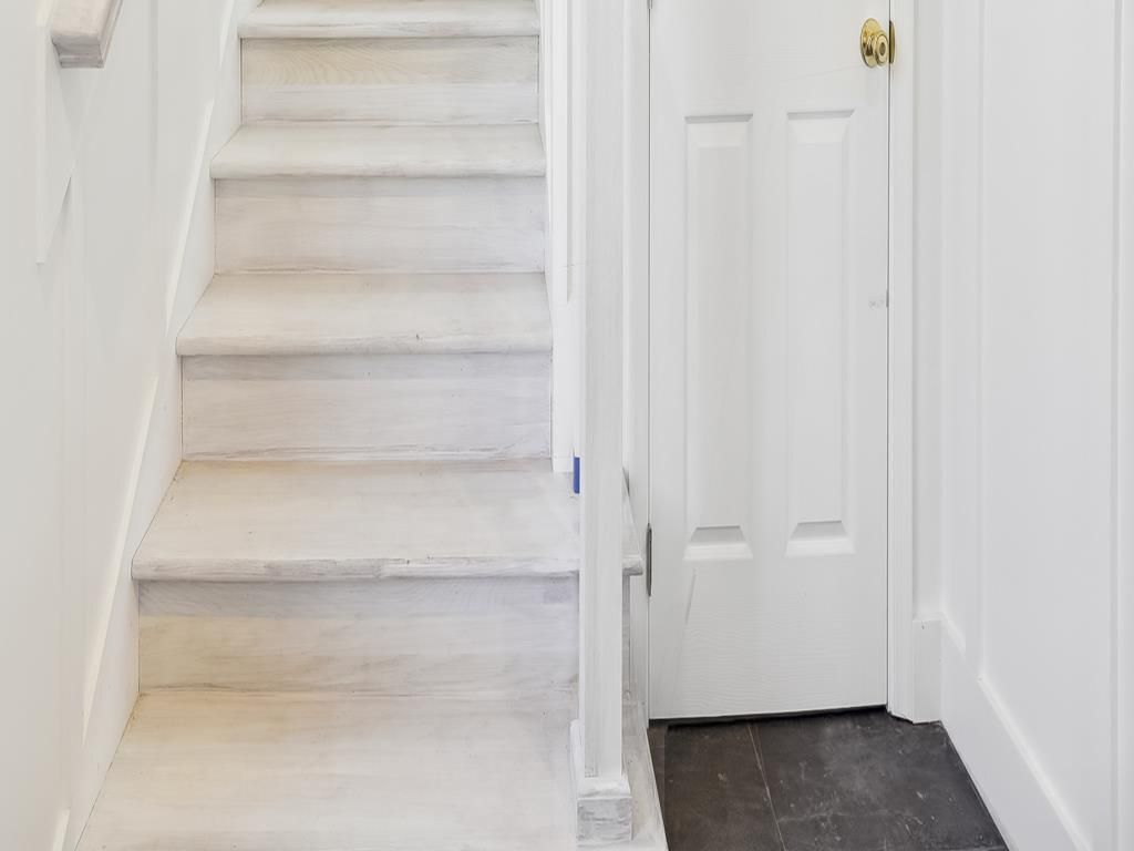 A staircase leading to a white door with a brass doorknob.