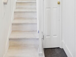 A staircase leading to a white door with a brass doorknob.
