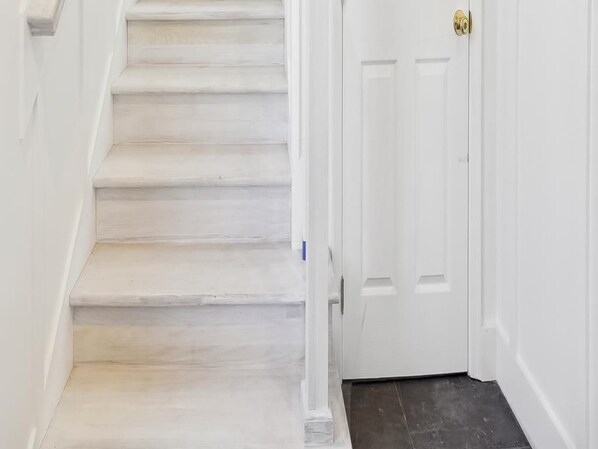 A staircase leading to a white door with a brass doorknob.