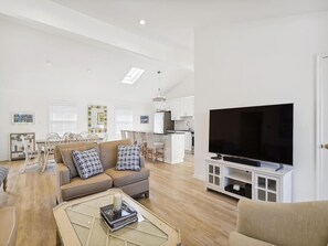 A modern living room with a sofa, coffee table, and a flat-screen TV.