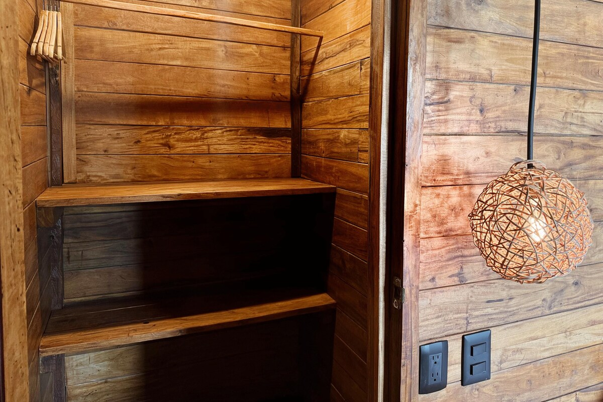 Un interior de madera con una estantería y una lámpara colgante.