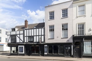 A row of buildings with a pub named "The Old Restoration" and a cafe.