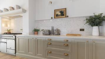 A kitchen with a built-in stove, cabinets, and a countertop with various appliances.