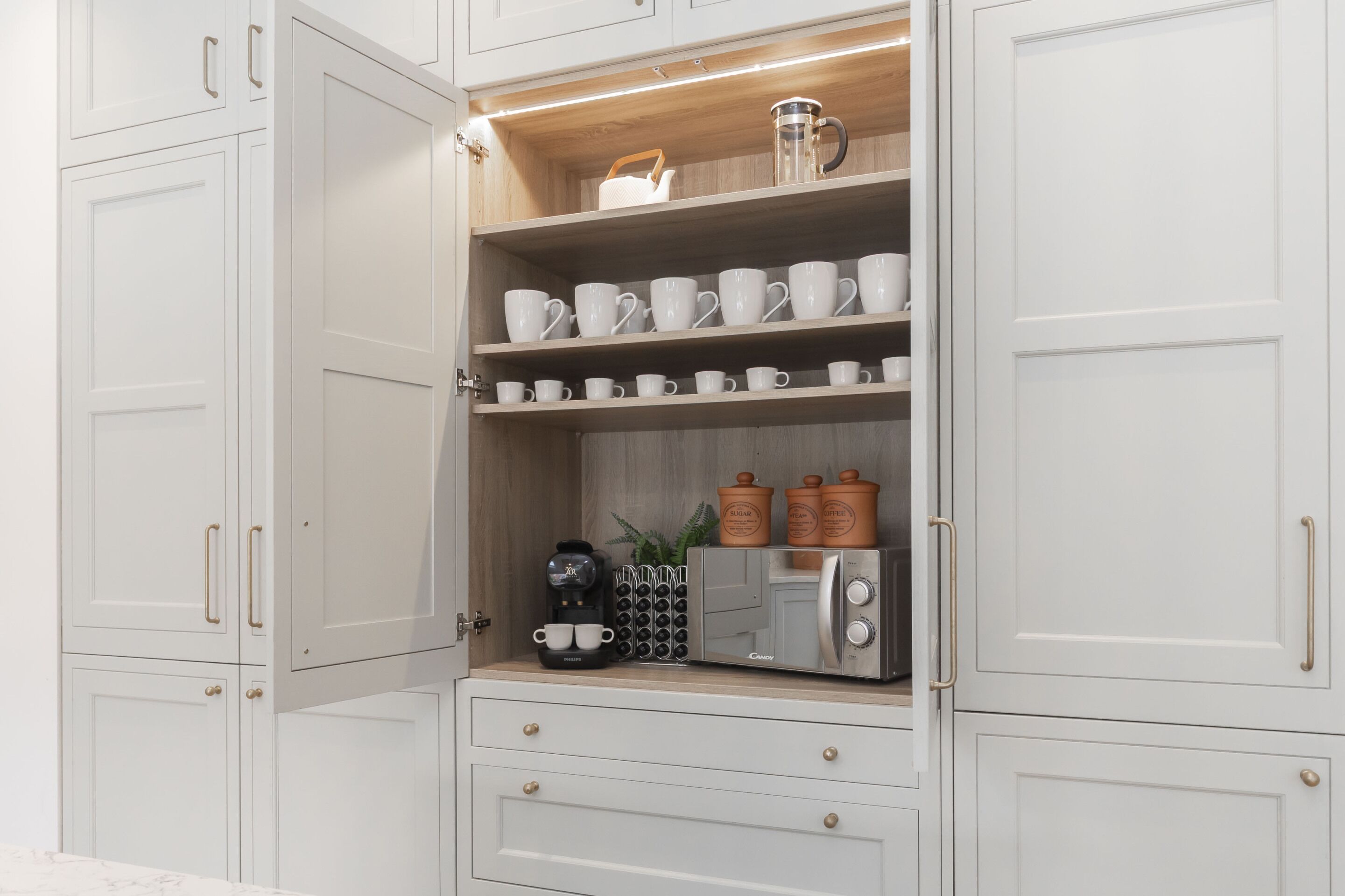 A kitchen with white cabinets, a coffee machine, and a toaster.
