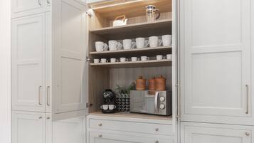 A kitchen with white cabinets, a coffee machine, and a toaster.