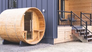 A wooden sauna attached to a modern building with a balcony and stairs. - Lakefront Cottage with Sauna- #3 Chinook (Wasilla)