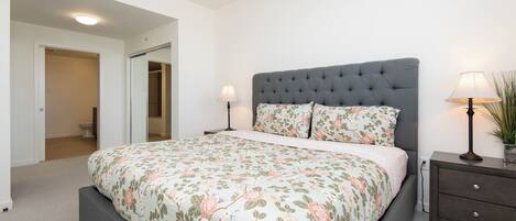 A bedroom with a large bed, two bedside tables, and a nightstand.